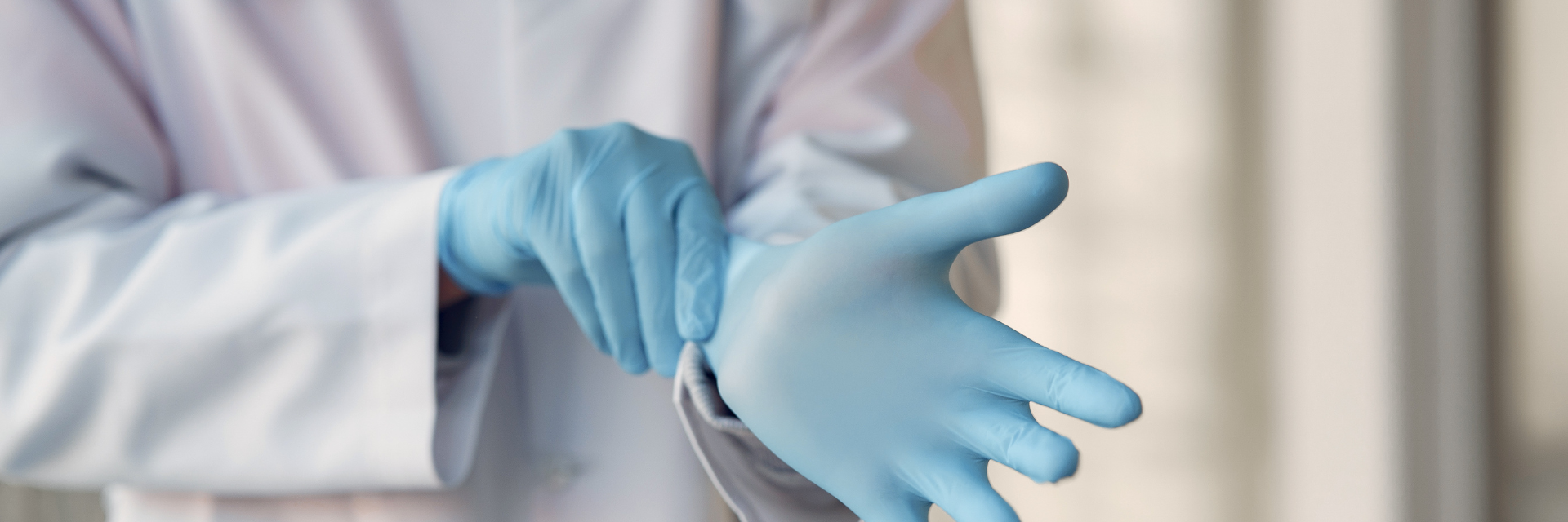 Medical spa staff member putting on disposable gloves before a skincare treatment Medical spa staff member putting on disposable gloves before a skincare treatment